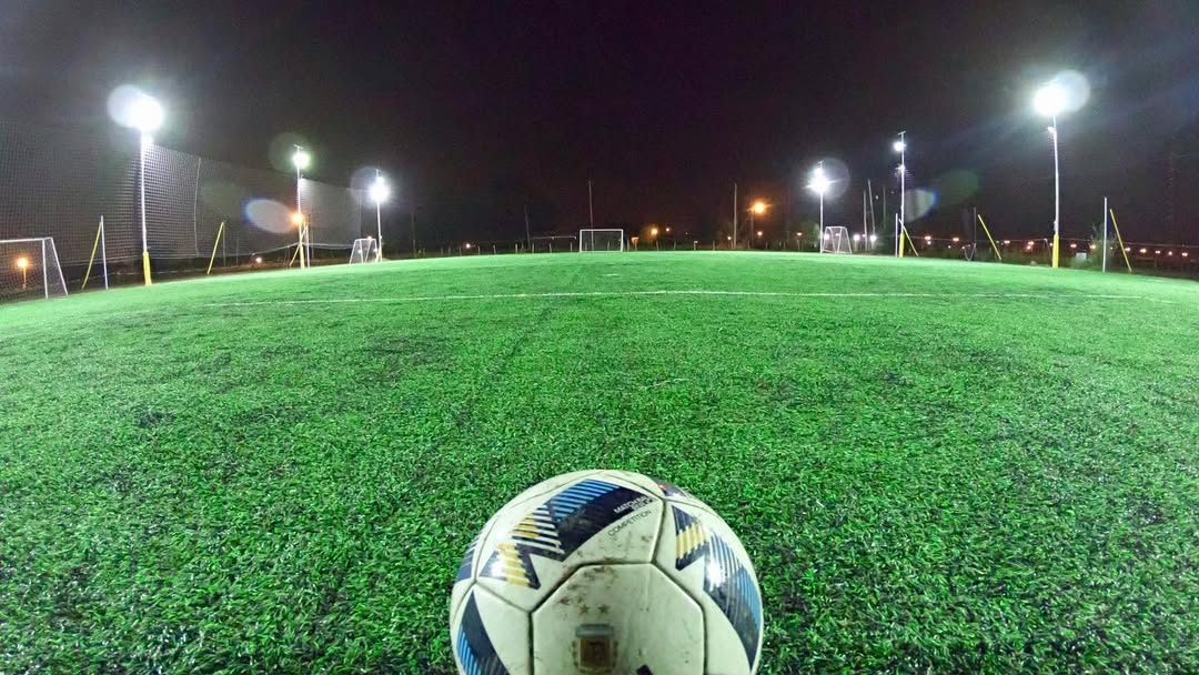 Balón de fútbol en cancha de noche